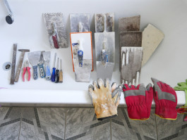 Werkzeug und Handschuhe in einer Badewanne